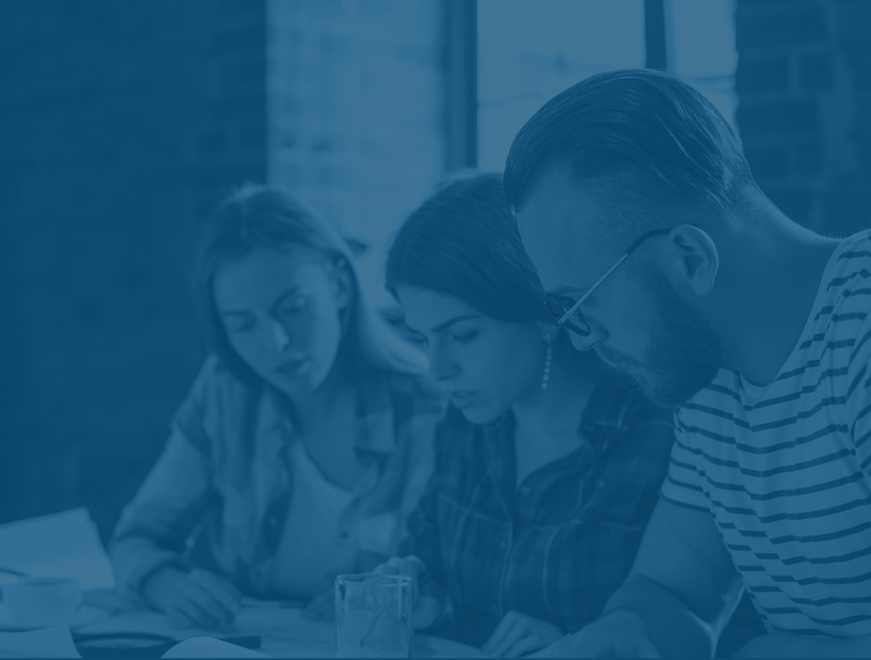 Two women and a man looking at a project while working as a team